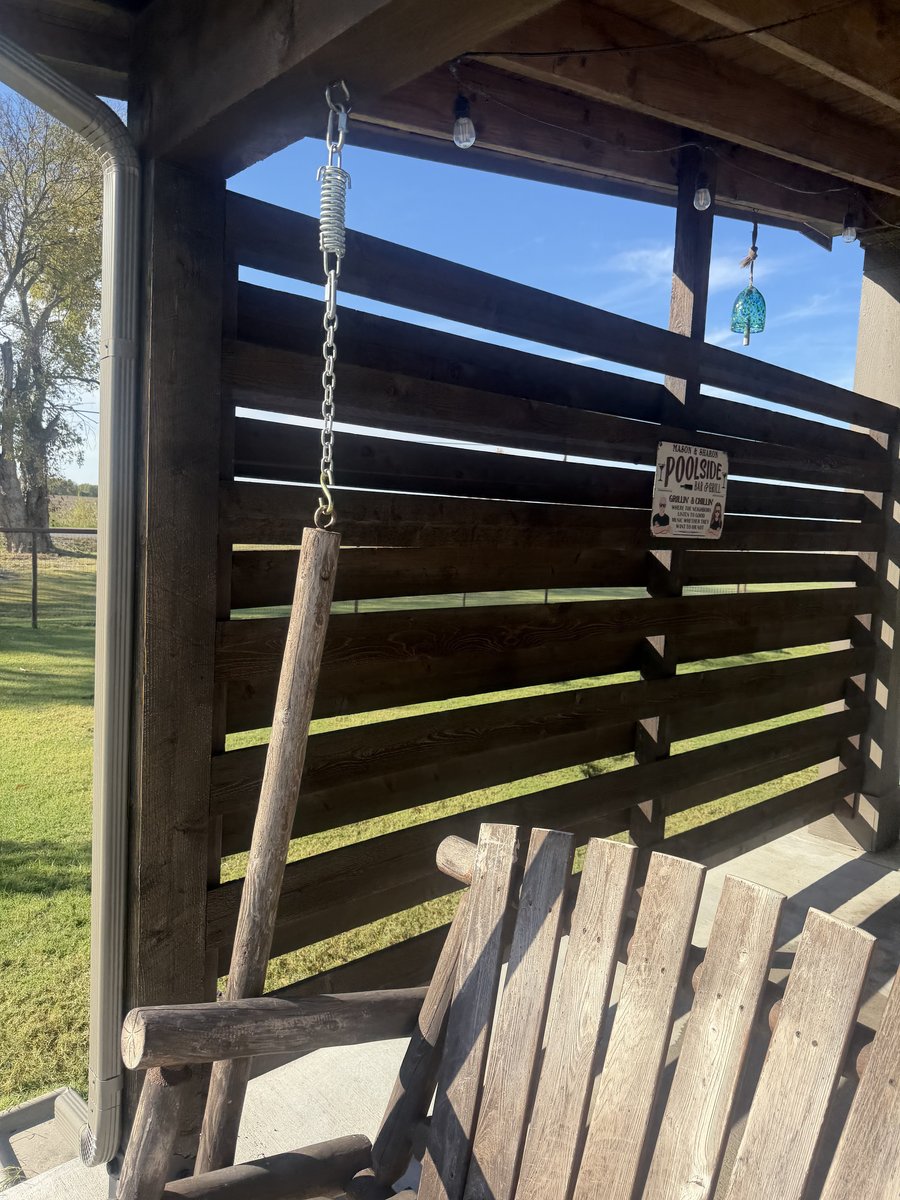 Pergola swing area with horizontal slat privacy wall