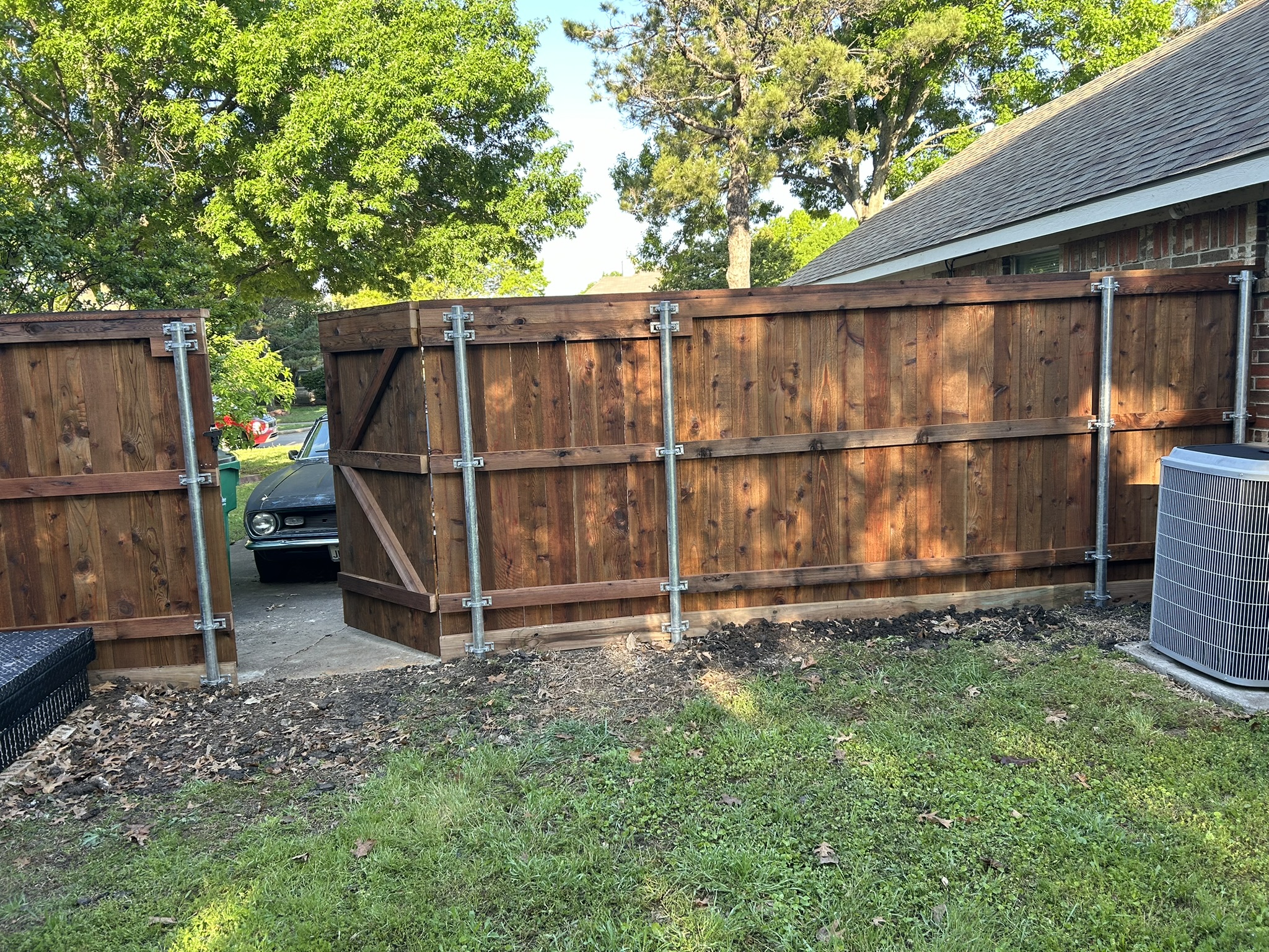 Cedar privacy fence with wood gate and metal hardware viewed from back side