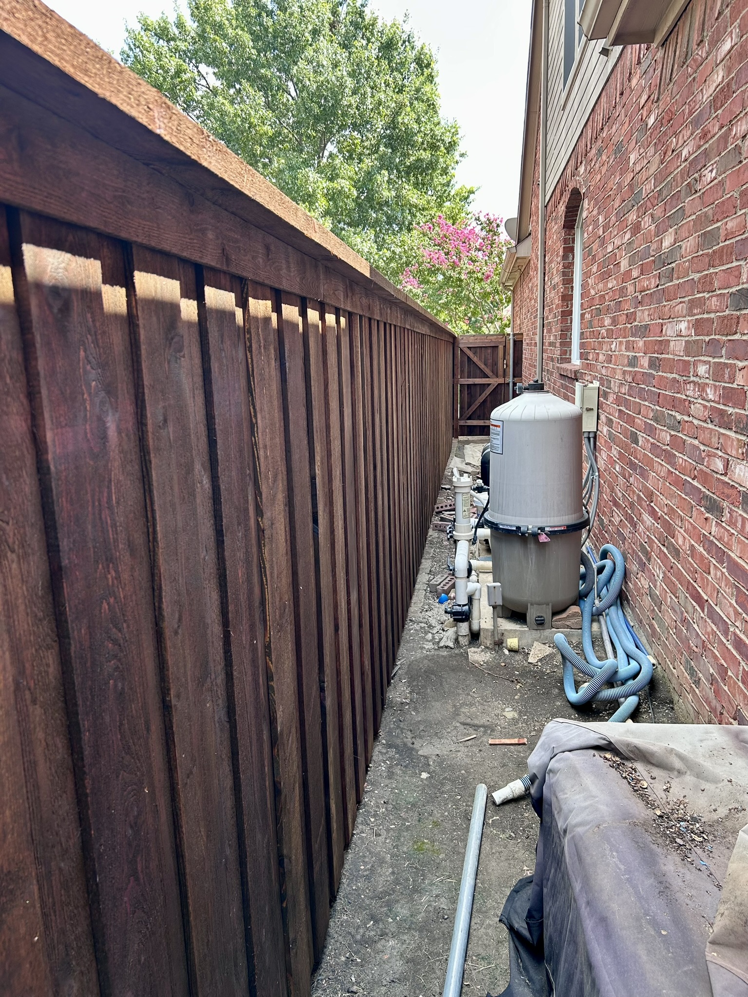Stained cedar board-on-board fence alongside a backyard pool area