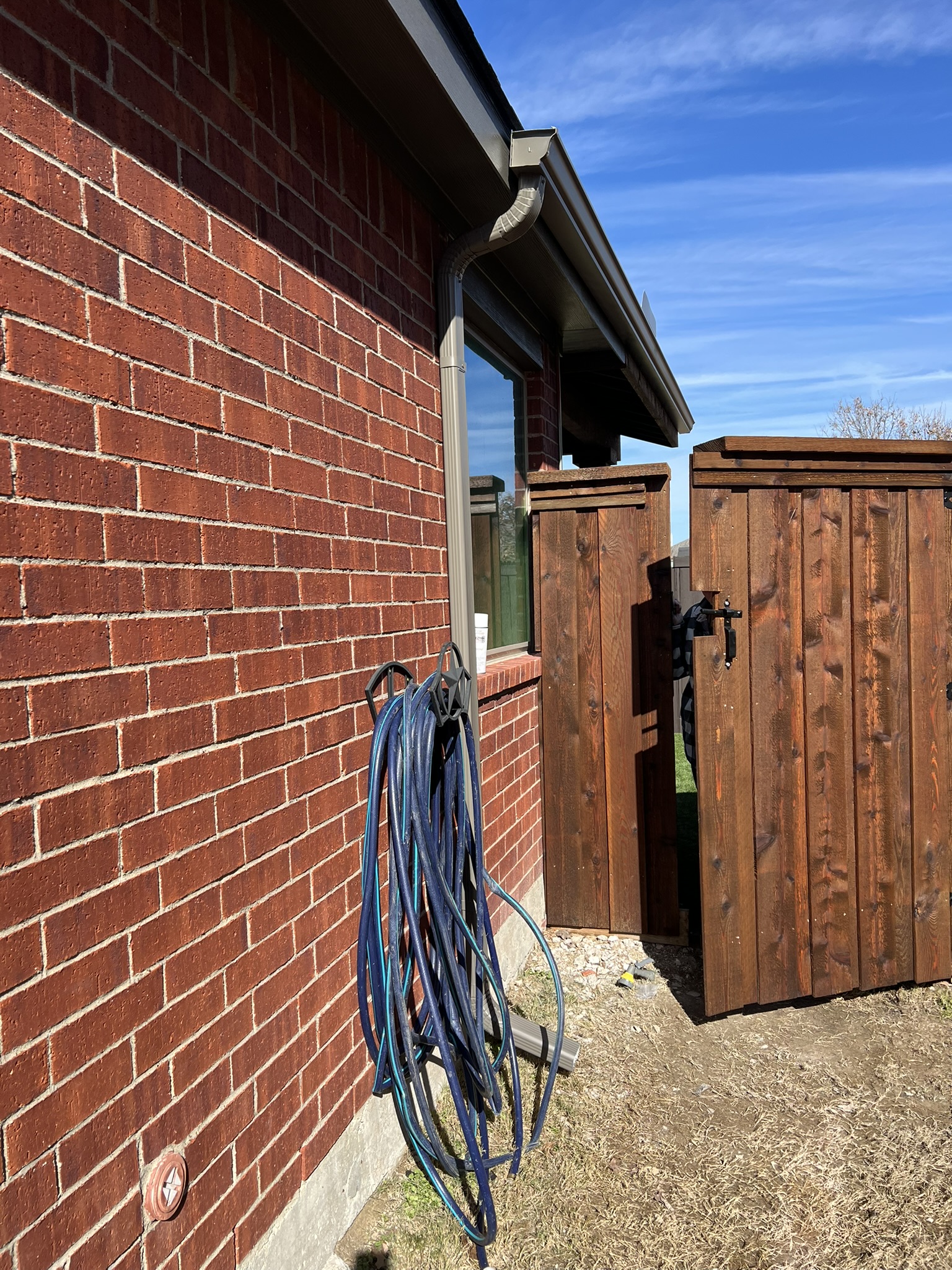 Dark stained cedar board-on-board fence under construction in a side yard