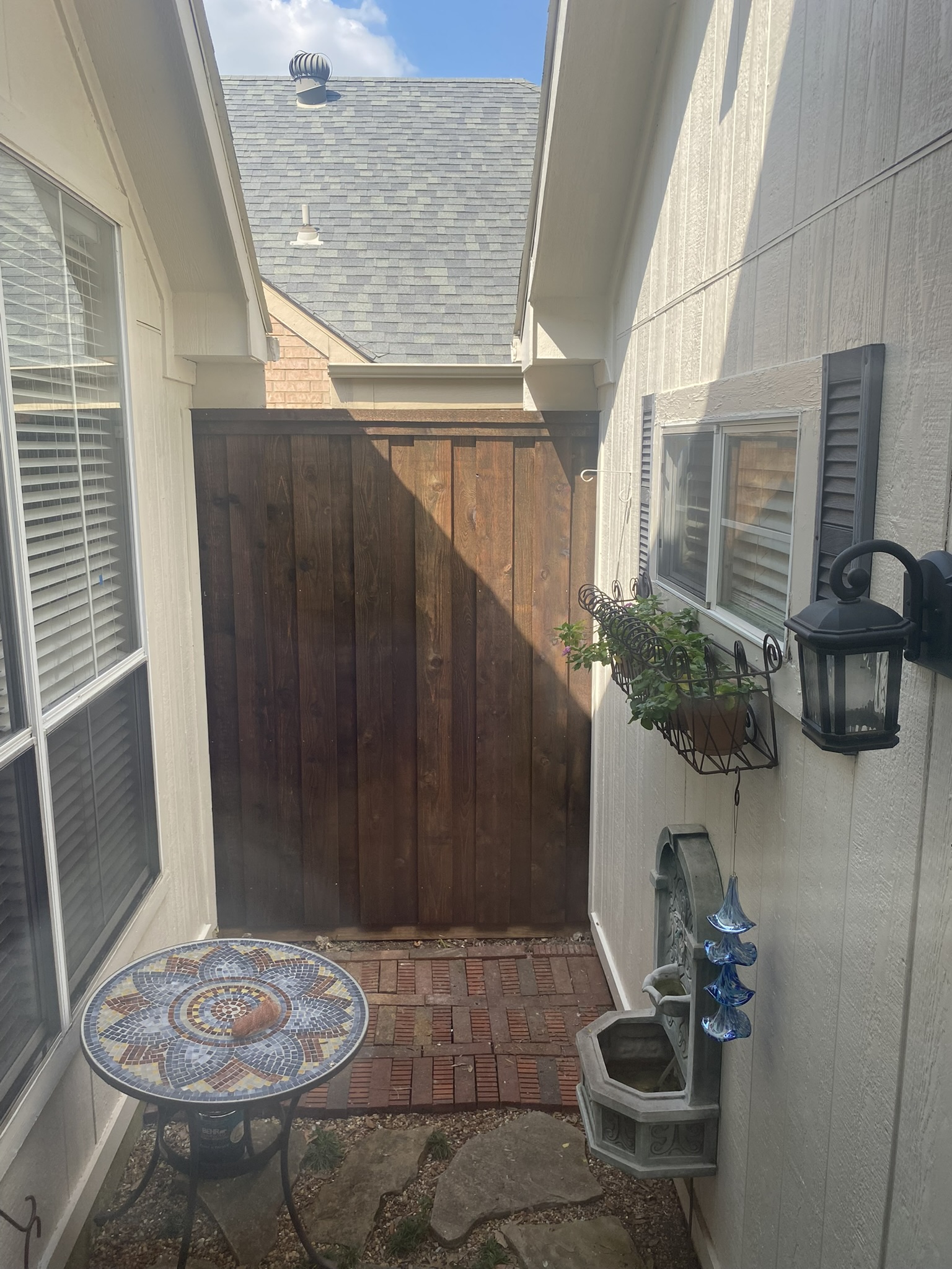 Stained cedar wood gate in narrow side yard between houses
