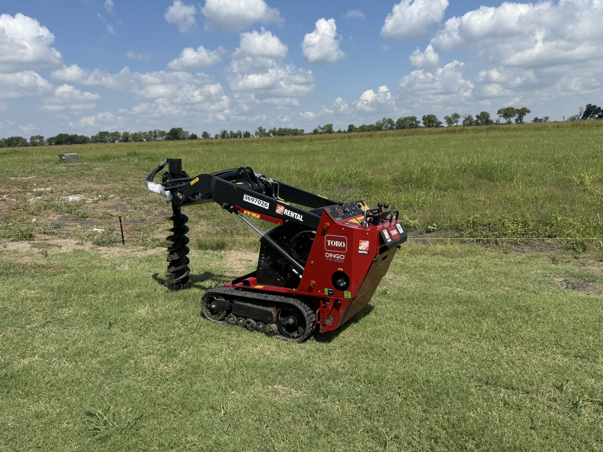 Toro Dingo compact utility loader with auger attachment for fence post installation