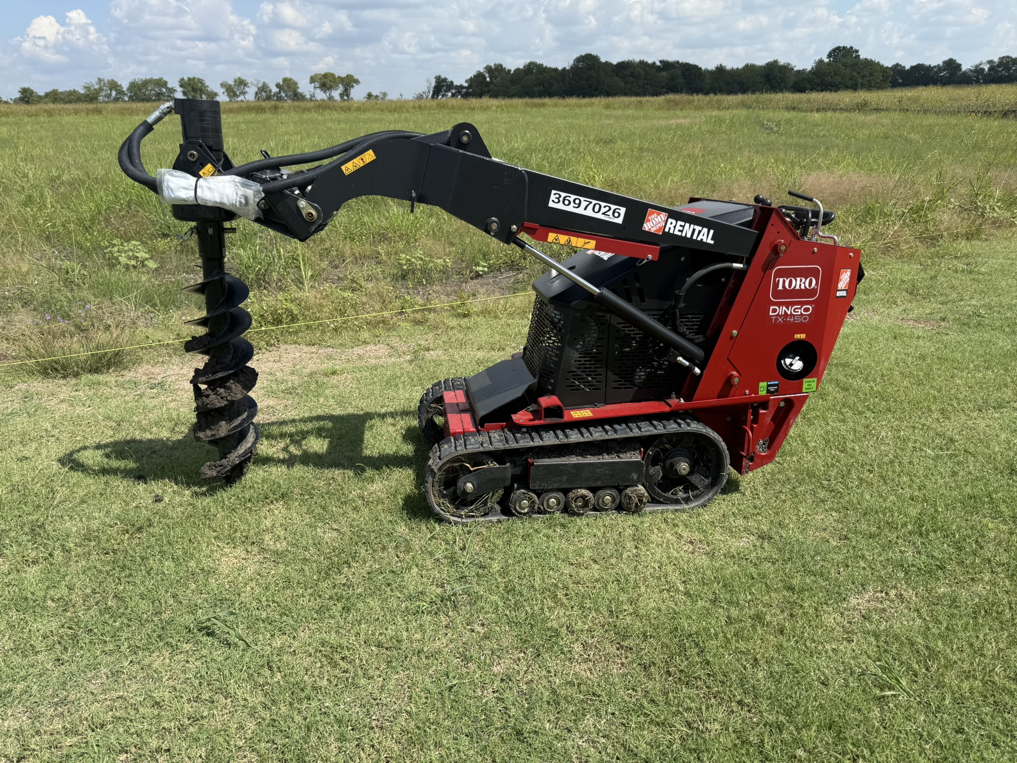 Toro Dingo compact utility loader with auger for fence post hole digging