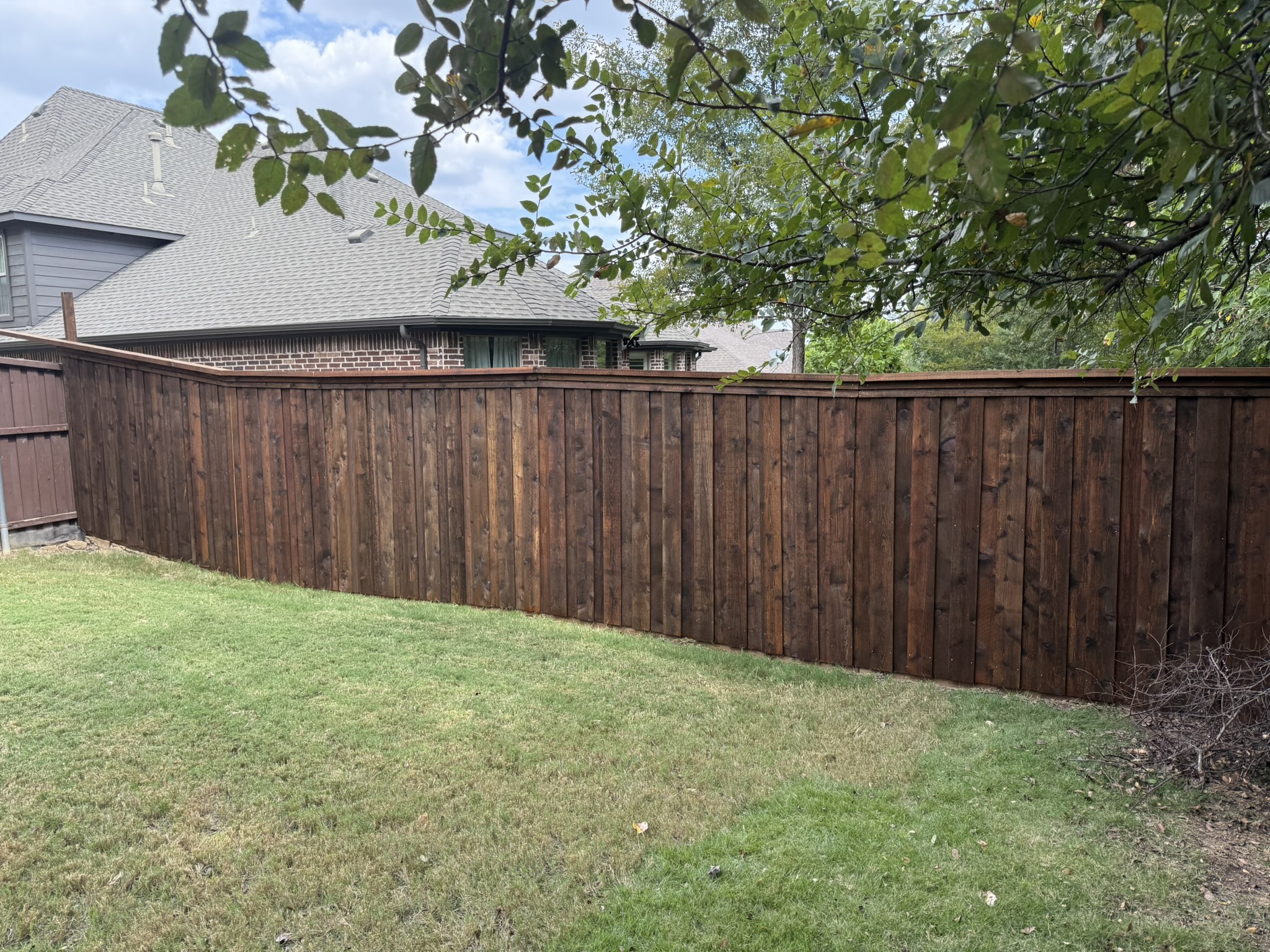 Stained cedar privacy fence with double gate and decorative iron hinges