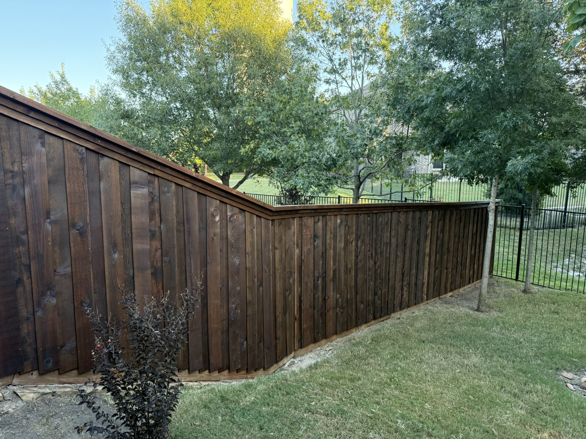 Stained cedar privacy fence stepping down hillside