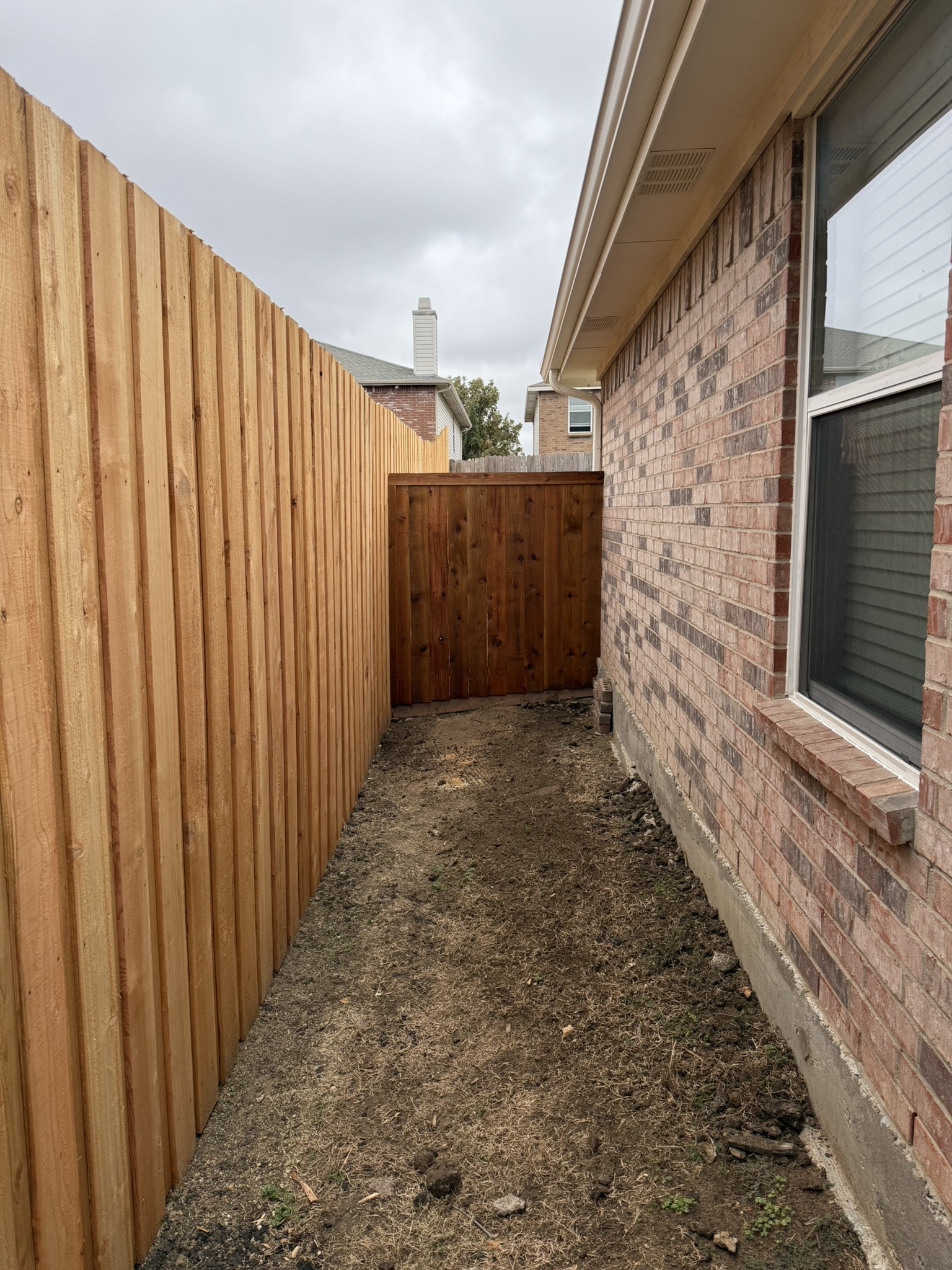 New cedar and stained cedar fence sections meeting at corner