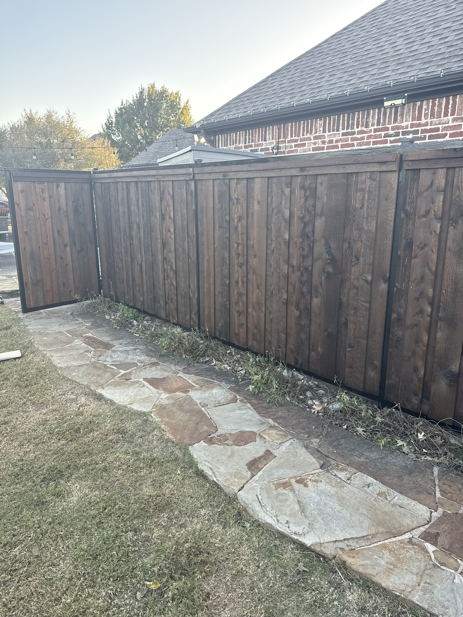 New cedar board-on-board privacy fence along alley with houses in background