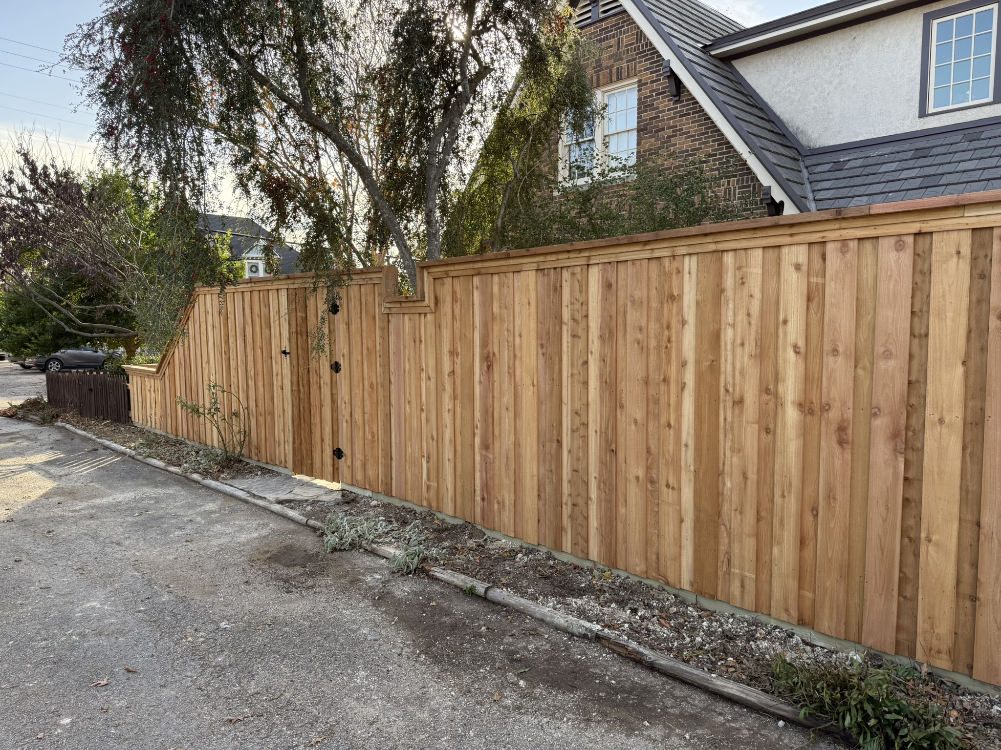 Back side of new cedar privacy fence showing metal posts and z-bracing