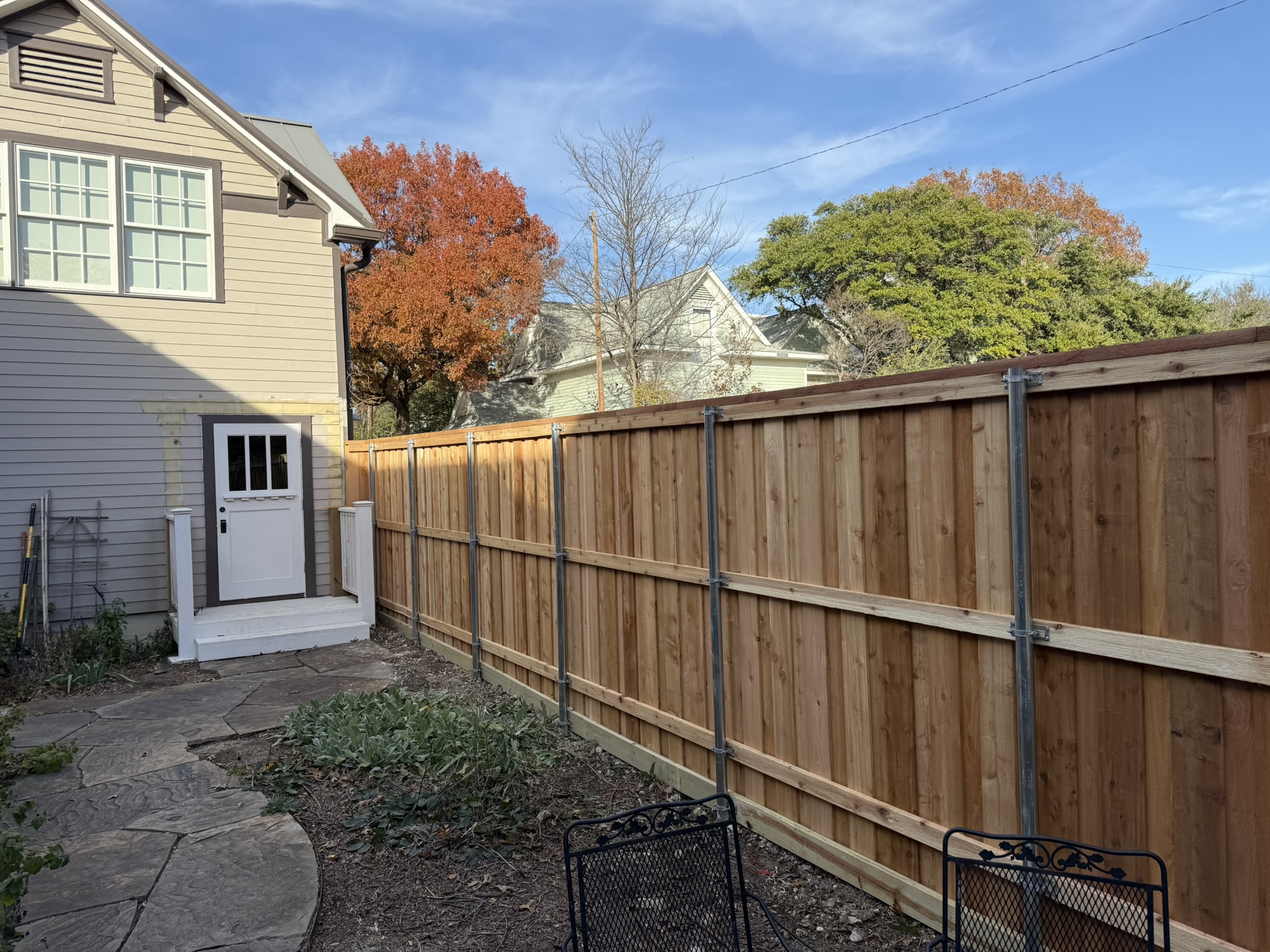 New cedar privacy fence at sunset with cap rail along backyard