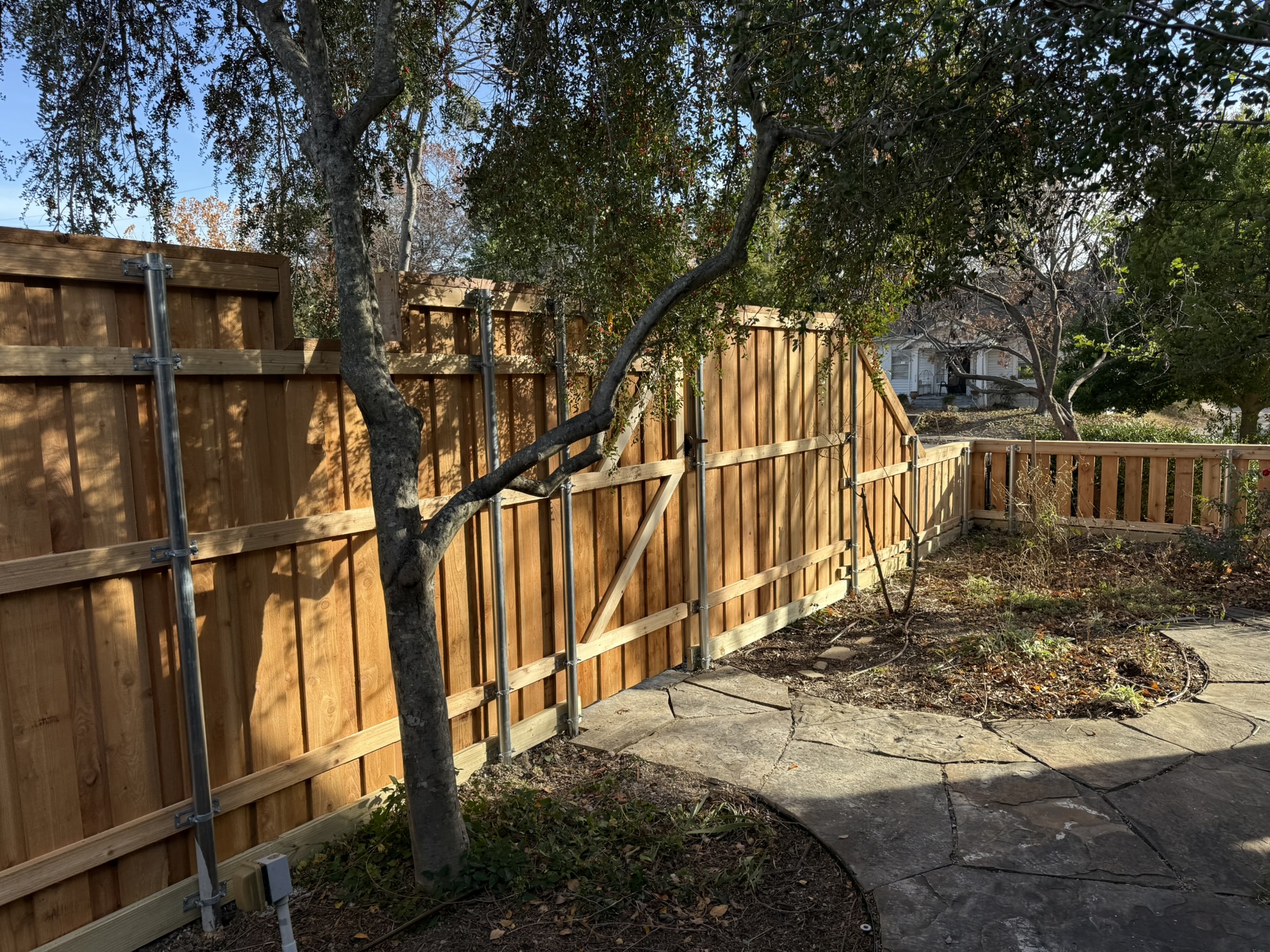 New cedar board-on-board fence with stepped picket transition at sunset