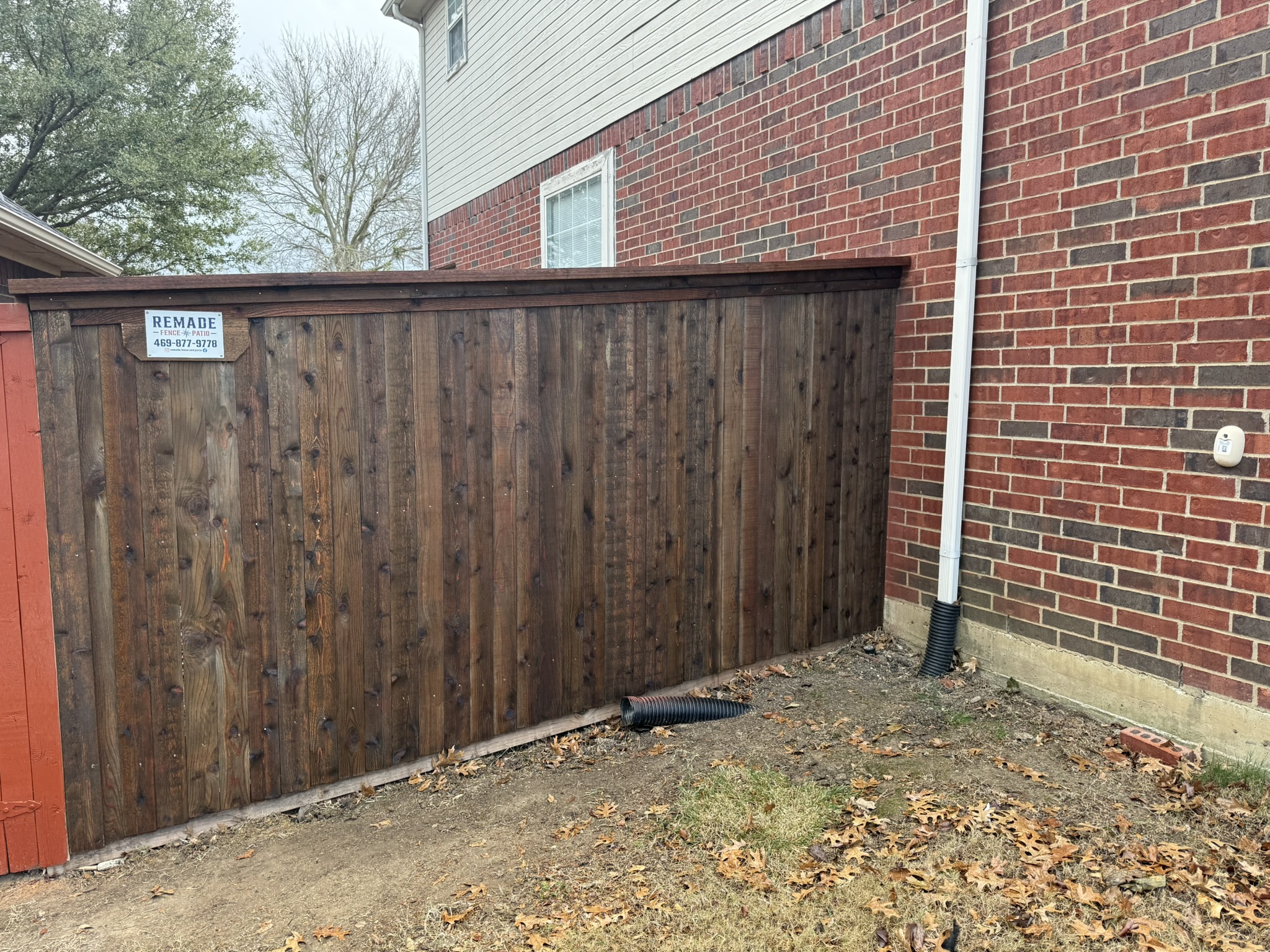 Back side of tall new cedar board-on-board privacy fence with horizontal rails
