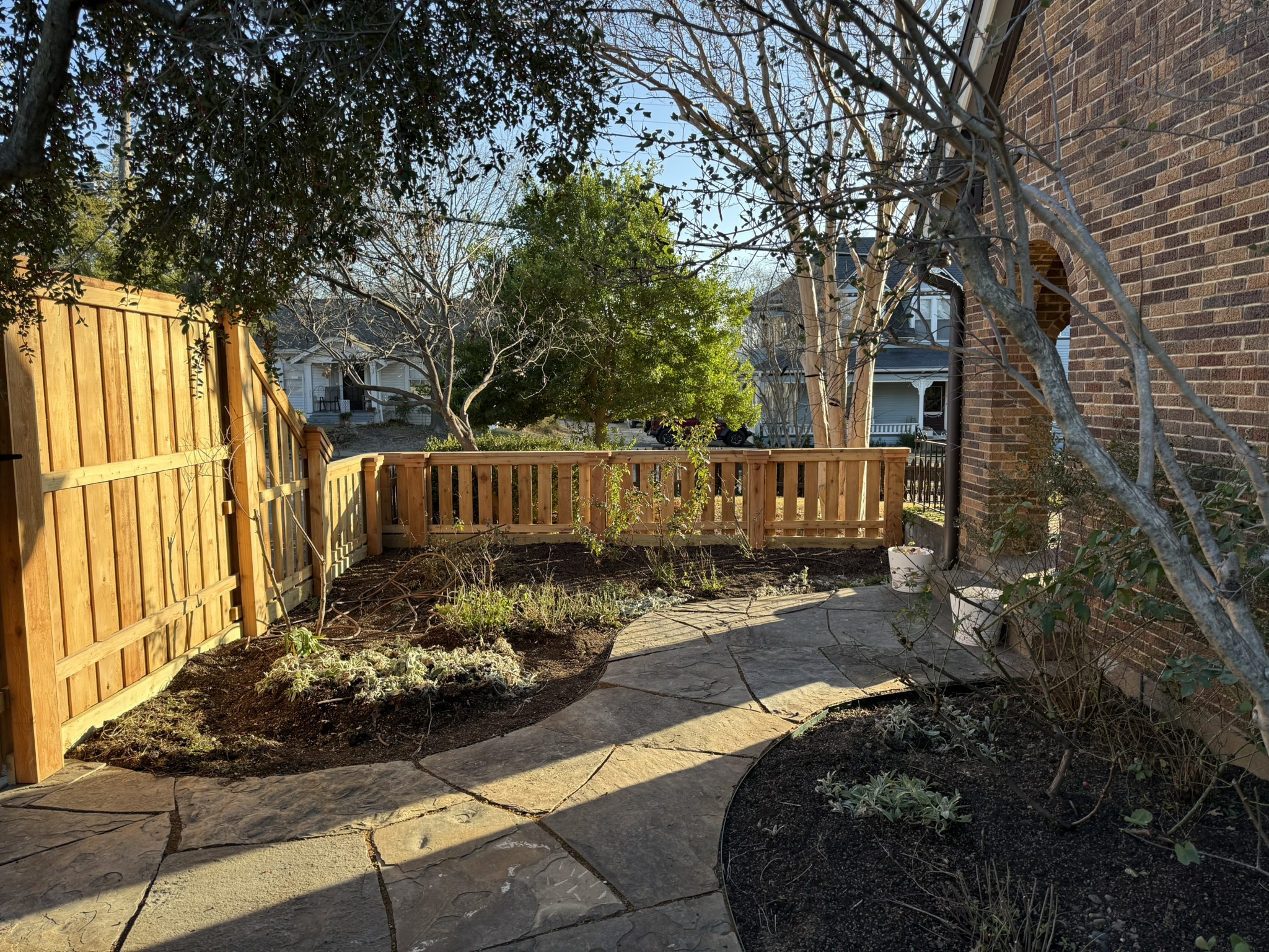 Back side of new cedar board-on-board privacy fence with patio furniture visible